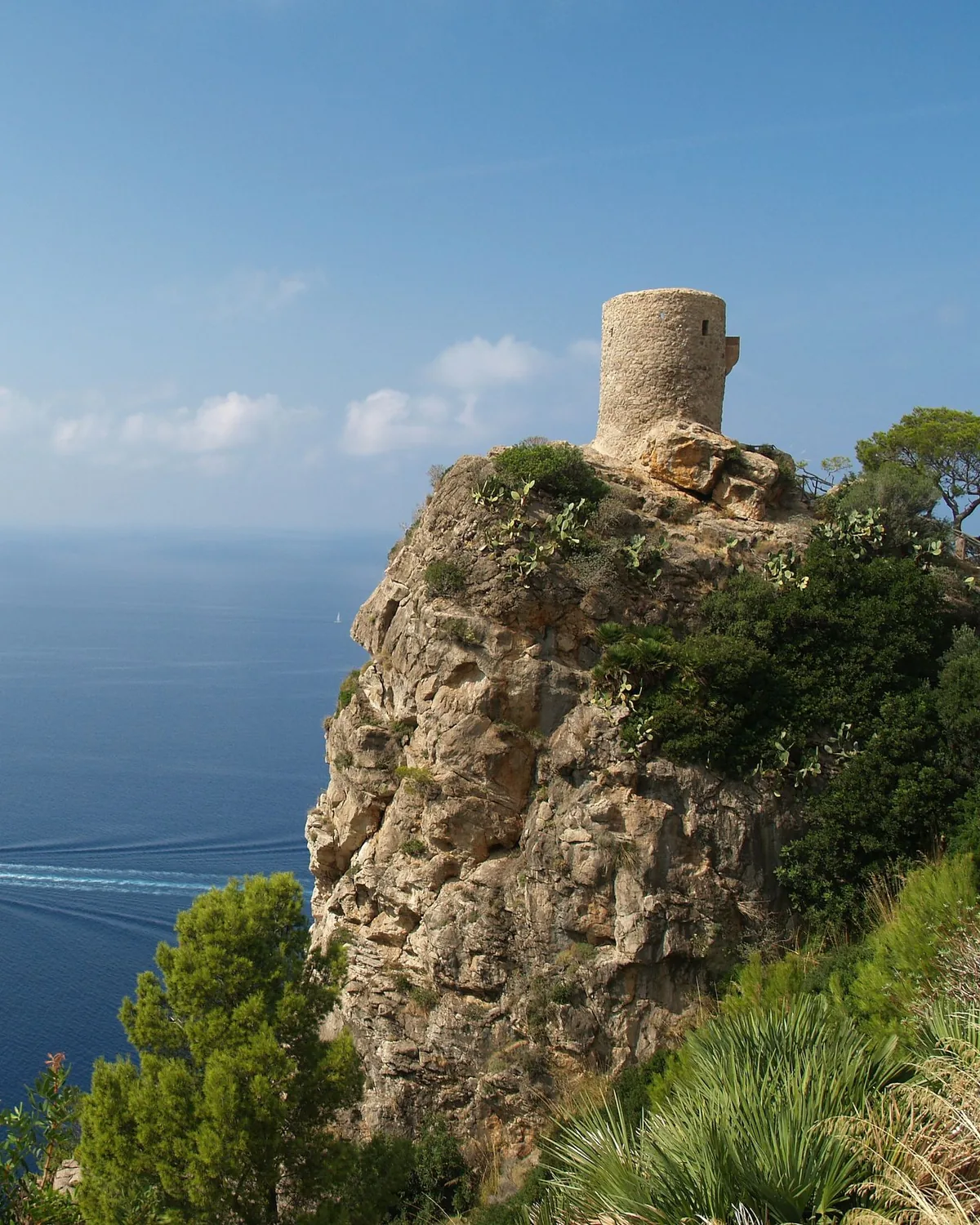 A historic stone watchtower on the cliffs above the Mallorcan coast